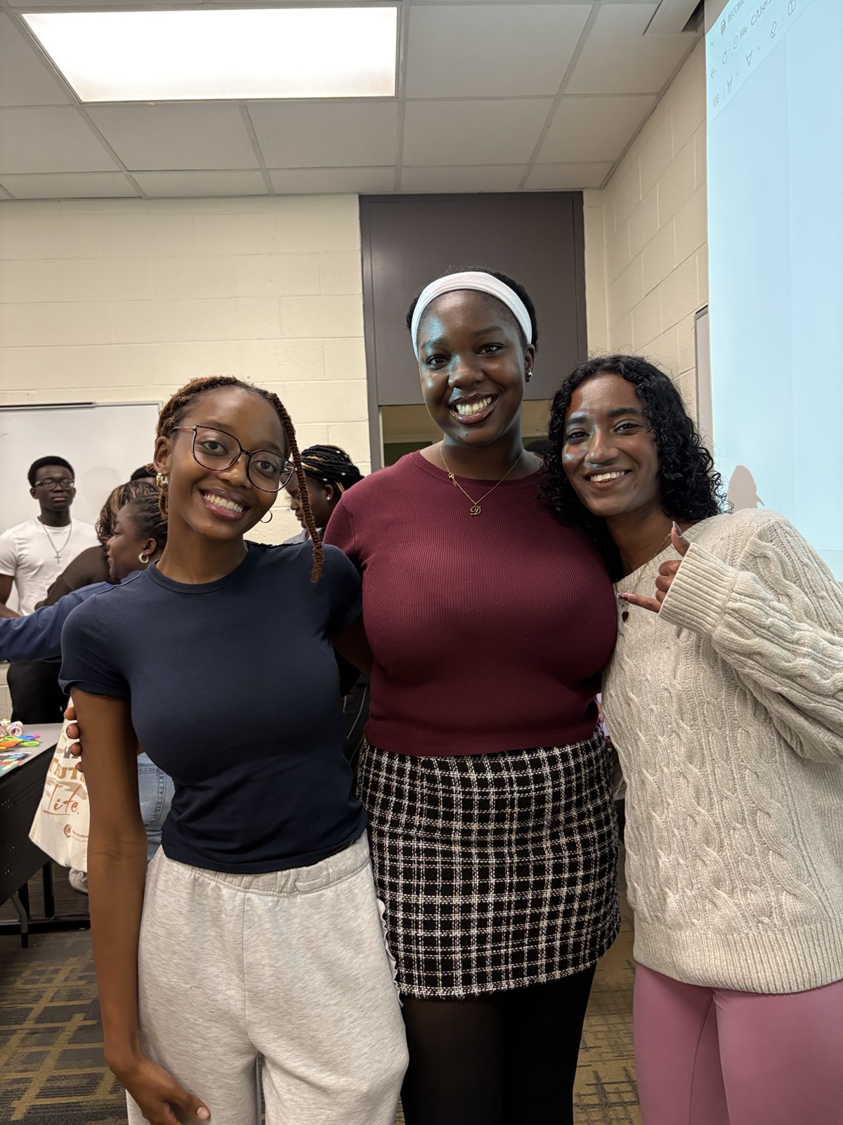 Three members smiling together at an NSBE MUN event